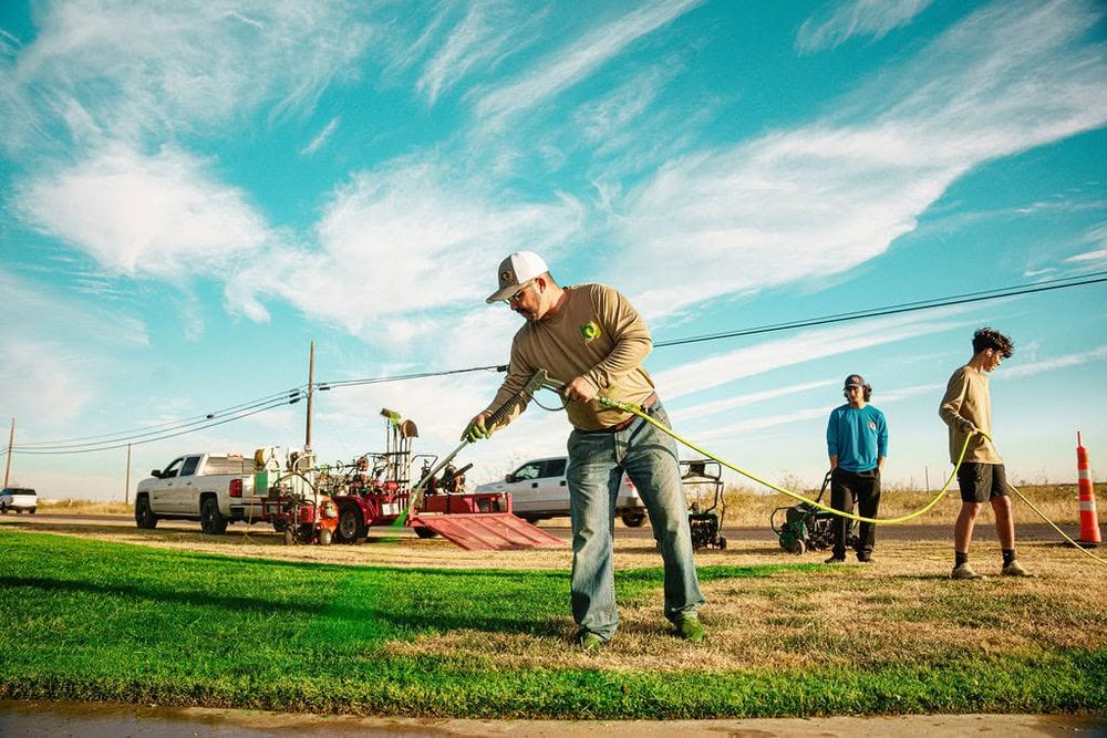 Spreading top dressing across a lawn at golden hour